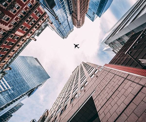 Traslado al aeropuerto, visión de una ciudad con un avión sobrevolando