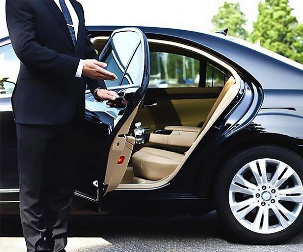 Executive Black car service, chauffeur open the car door
